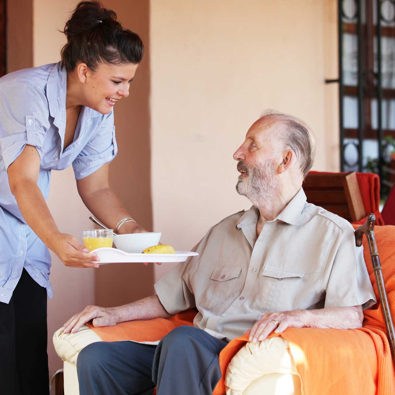 Photo of a caregiver serving breakfast to a senior home care client